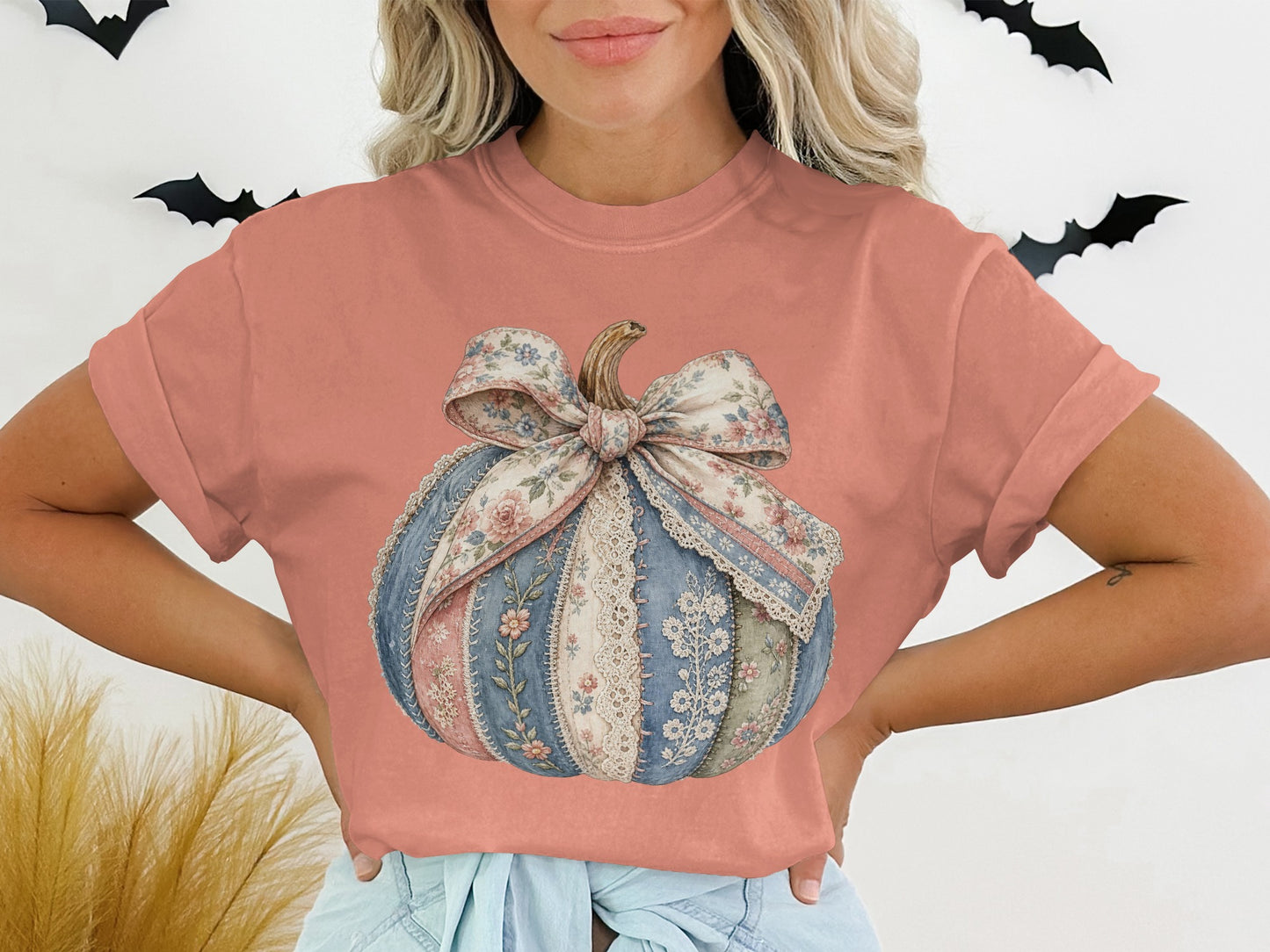 Patchwork pumpkin graphic with a floral bow on a coral t-shirt.