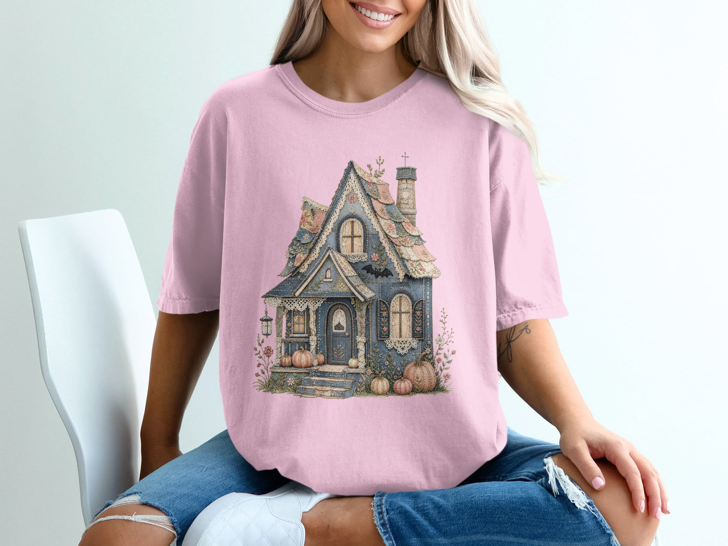 Pink t-shirt with a blue cottage design featuring pumpkins and floral accents.