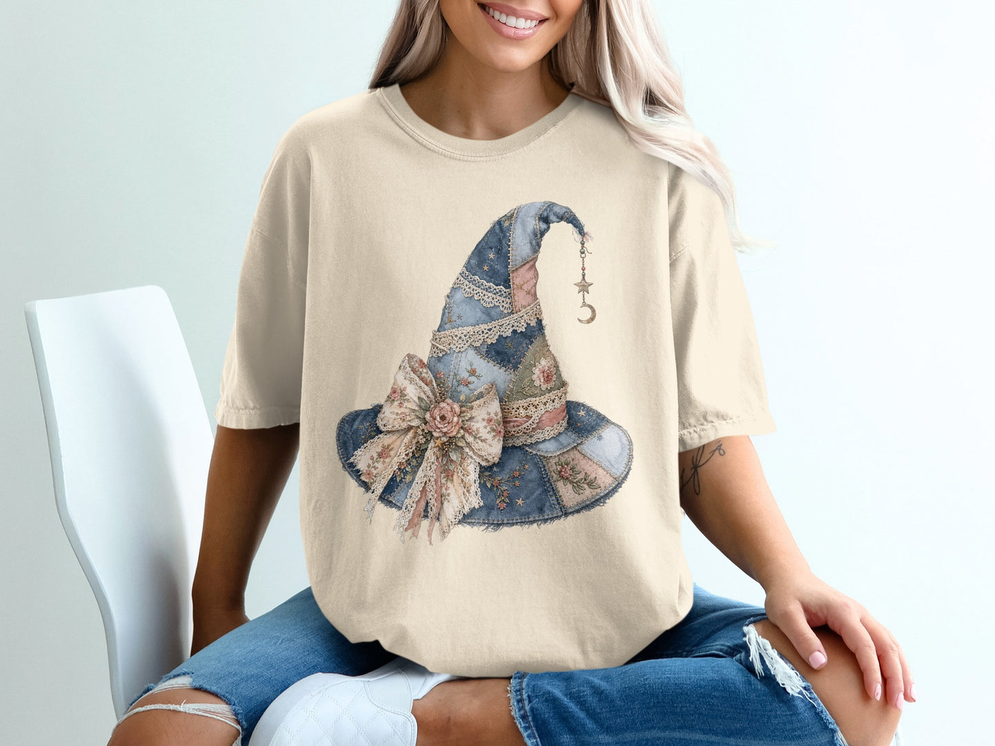 Light tan t-shirt with a watercolor-style witch hat graphic.