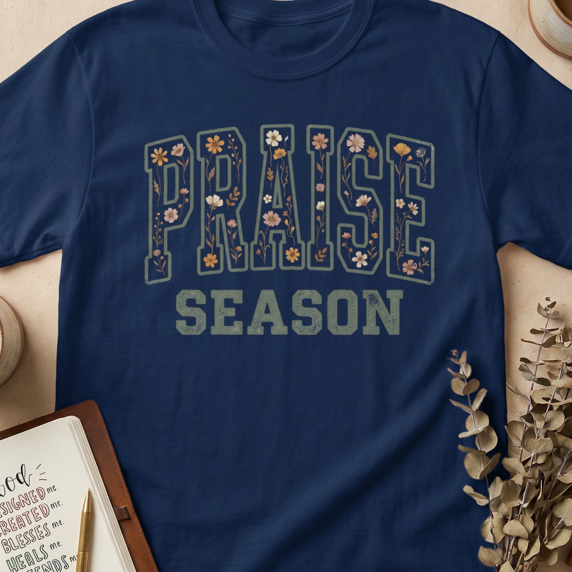 Navy t-shirt with "PRAISE SEASON" graphic featuring floral fill.