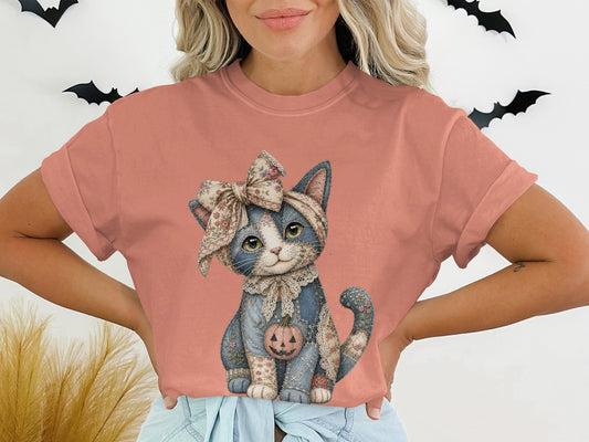 T-shirt with a stitched cat wearing a floral bow and holding a jack-o'-lantern.