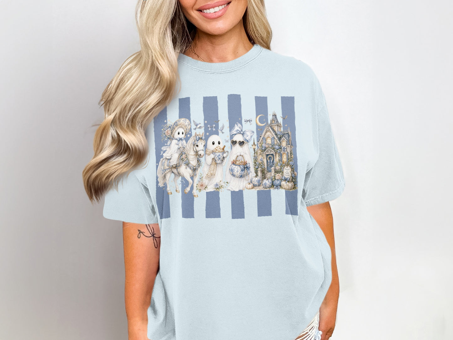 Ghost characters with pumpkins and haunted house on blue striped light blue t-shirt.