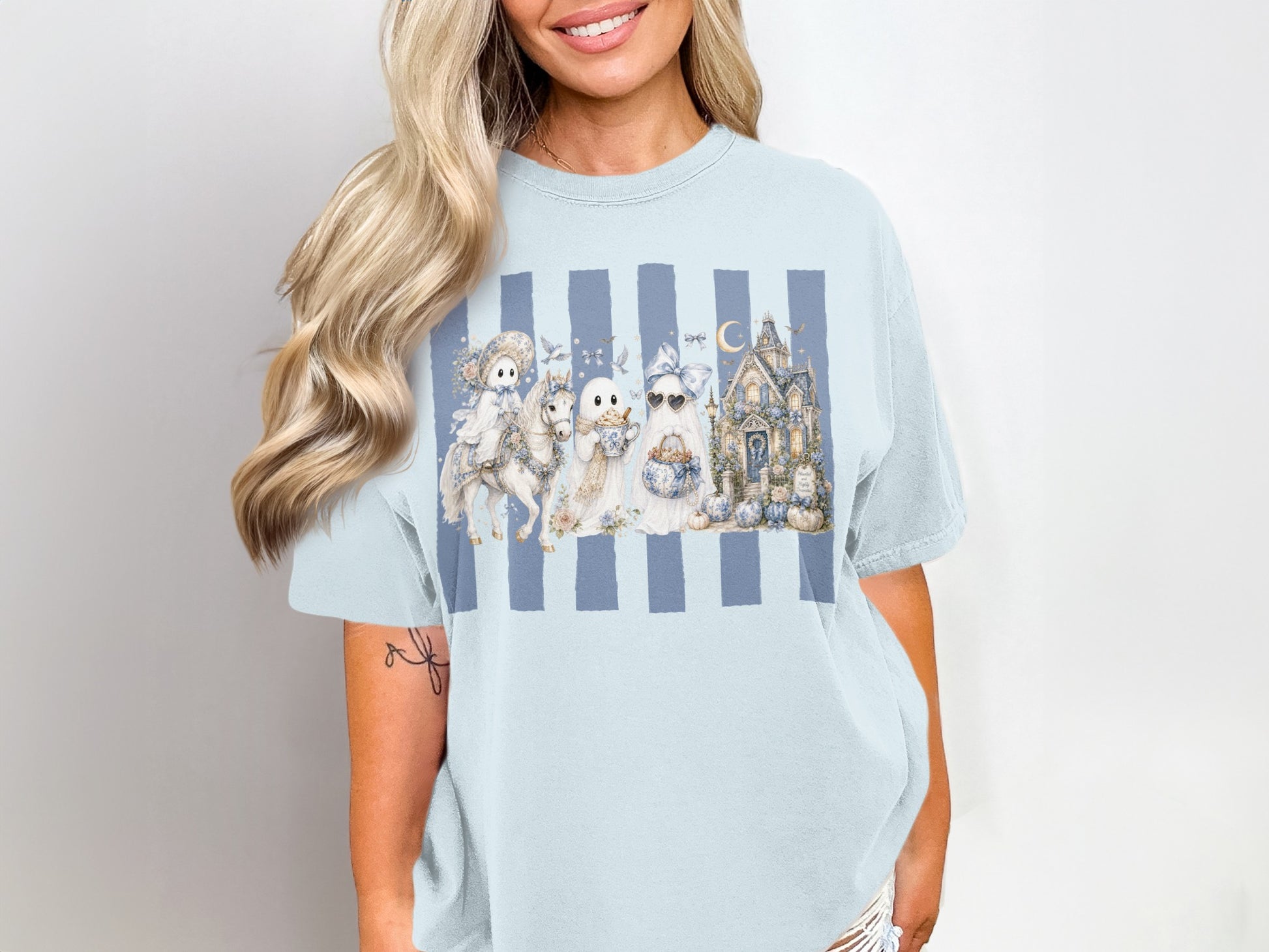 Ghost characters with pumpkins and haunted house on blue striped light blue t-shirt.