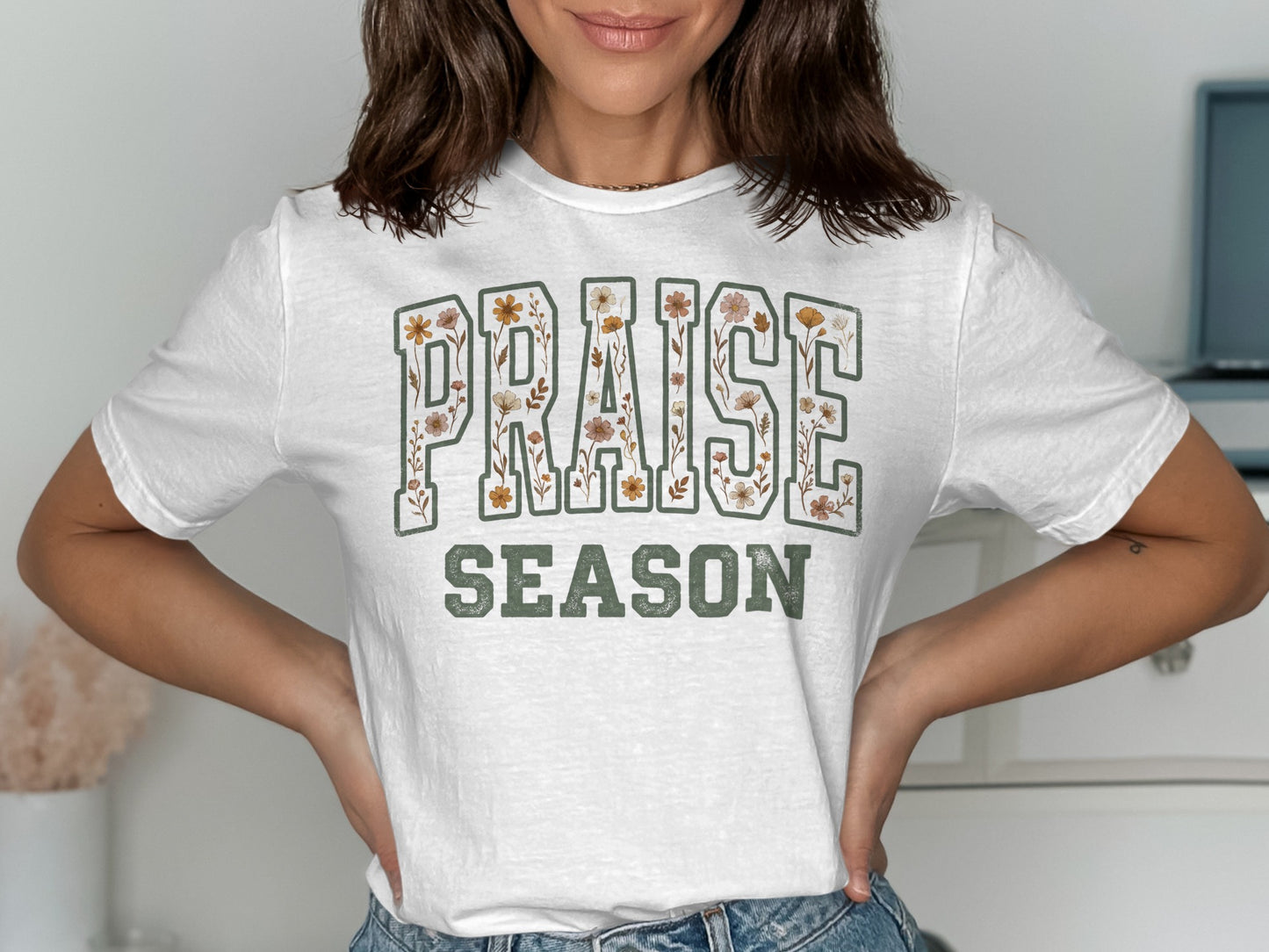 White t-shirt with "PRAISE SEASON" text featuring floral accents.