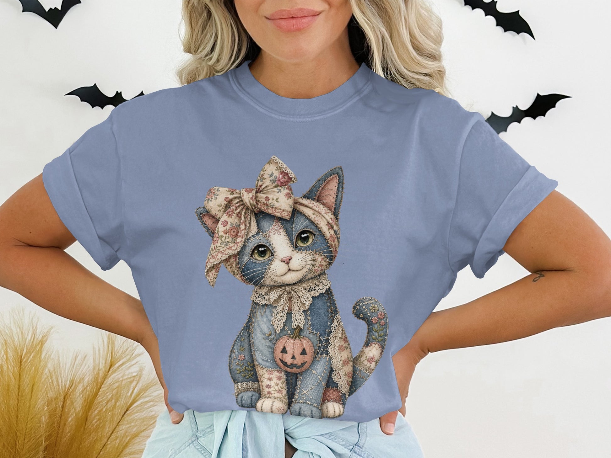 Blue t-shirt with patchwork cat wearing bow and holding a jack-o'-lantern.