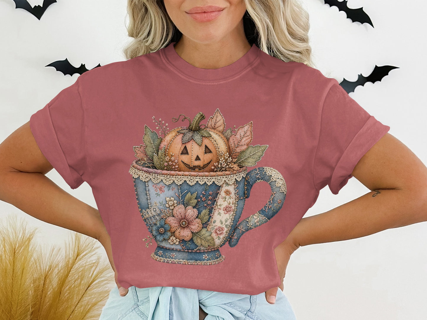 T-shirt with a watercolor graphic of a jack-o-lantern in a floral teacup.