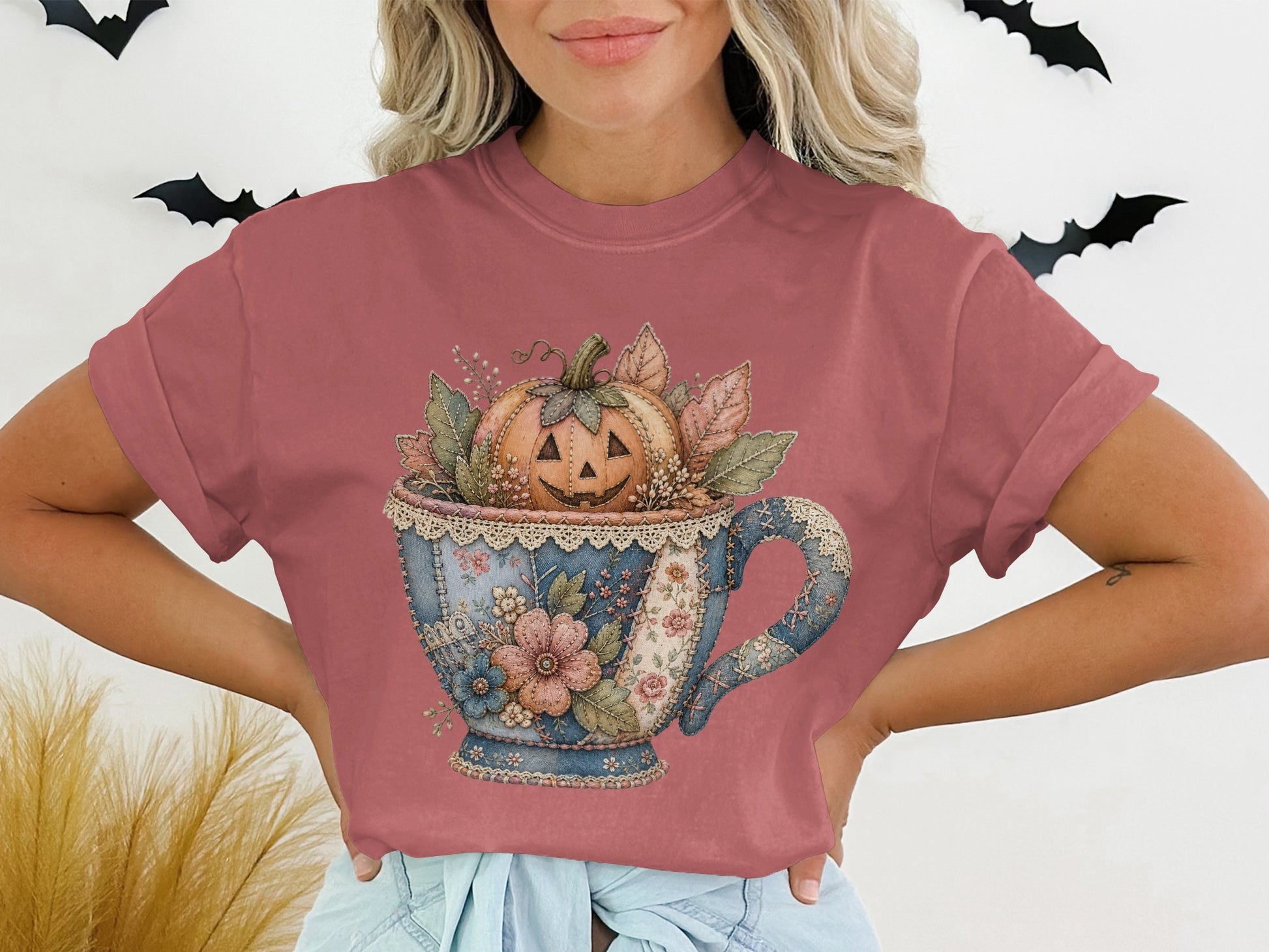 T-shirt with a watercolor graphic of a jack-o-lantern in a floral teacup.