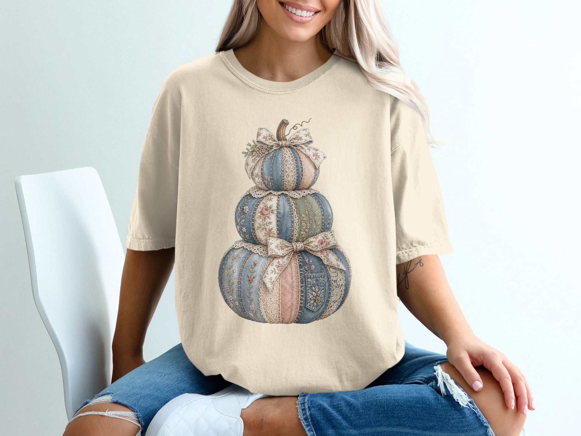 T-shirt with fabric-textured stacked pumpkins and bows graphic design.
