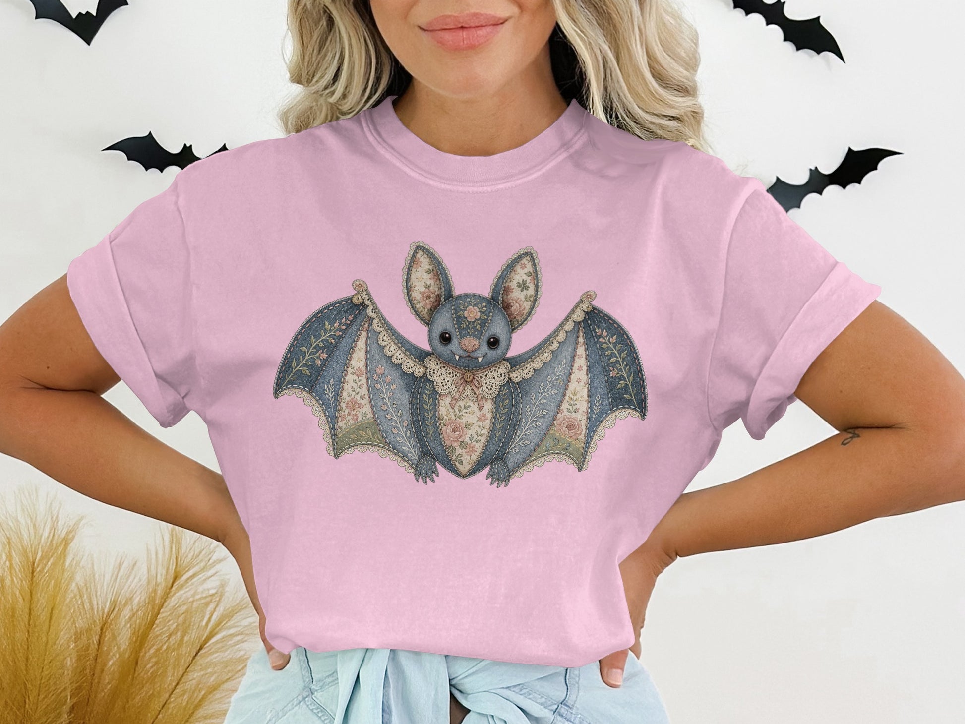 Pink t-shirt with a vintage-style floral bat graphic and black bat decorations.