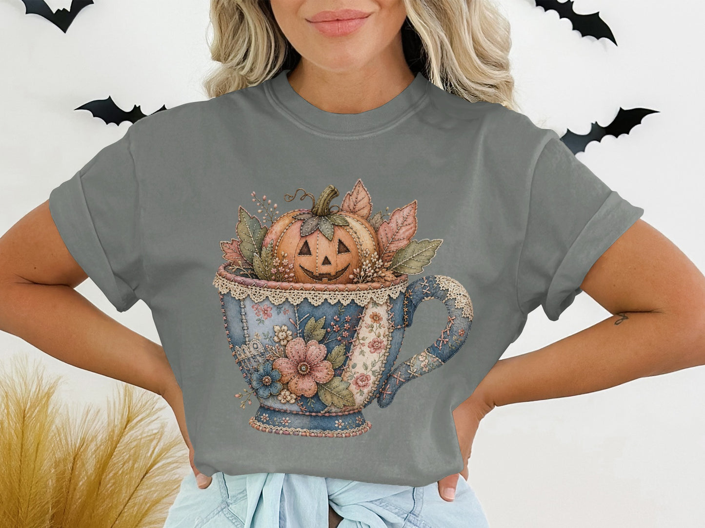 Jack-o'-lantern in a patchwork teacup with floral and leaf accents