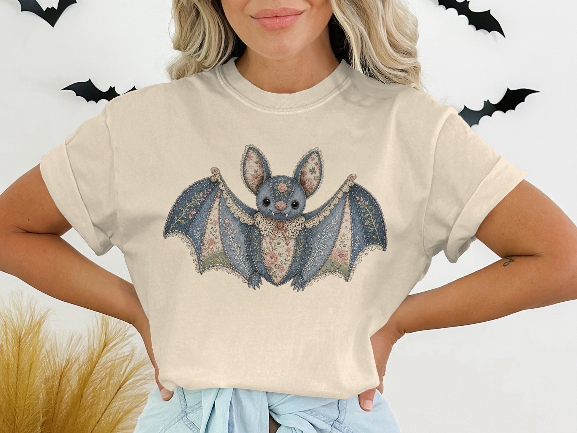T-shirt with a blue, floral decorative bat graphic and lace trim.