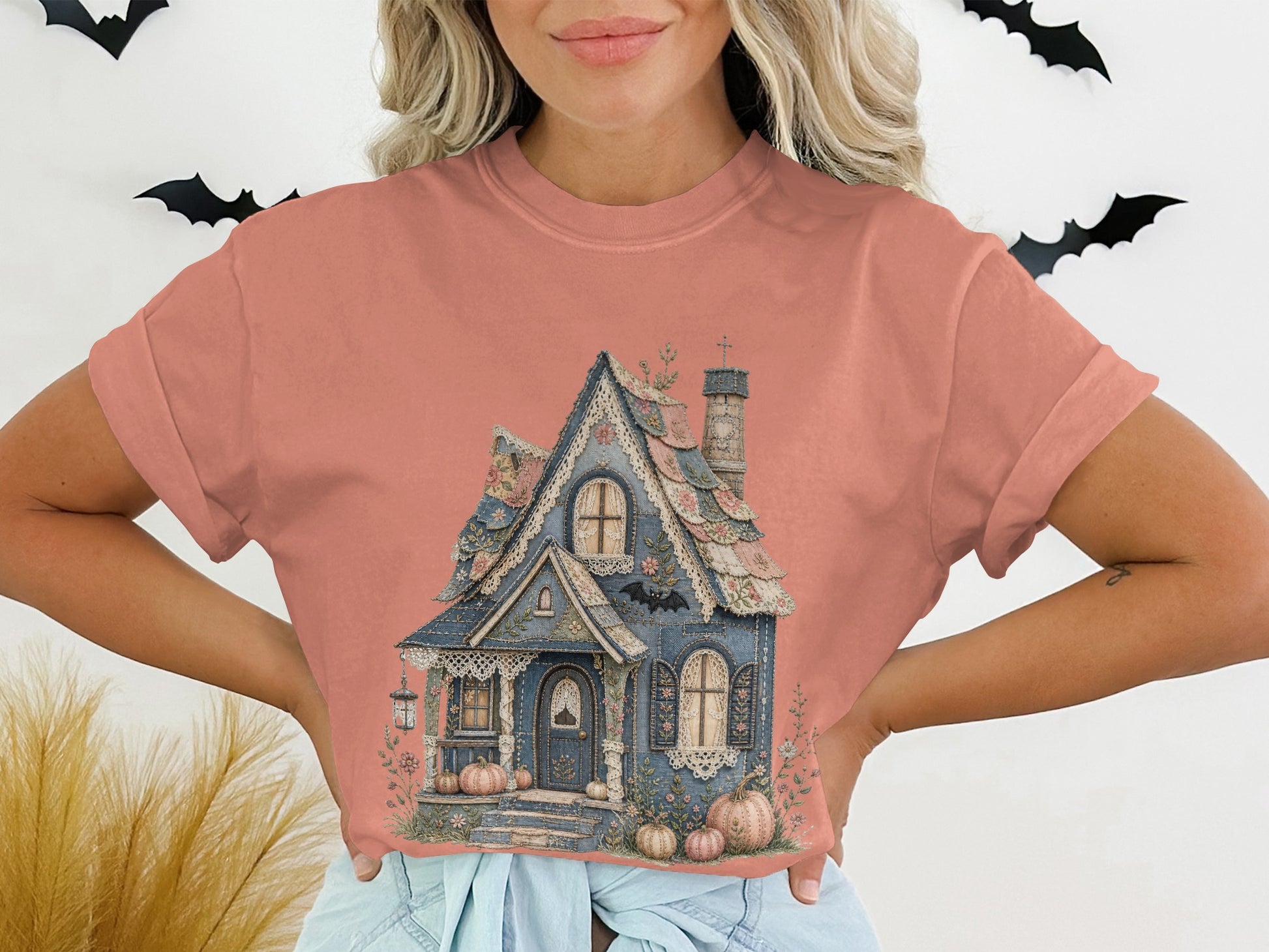 Cropped coral t-shirt with vintage-style haunted house graphic and pumpkins.
