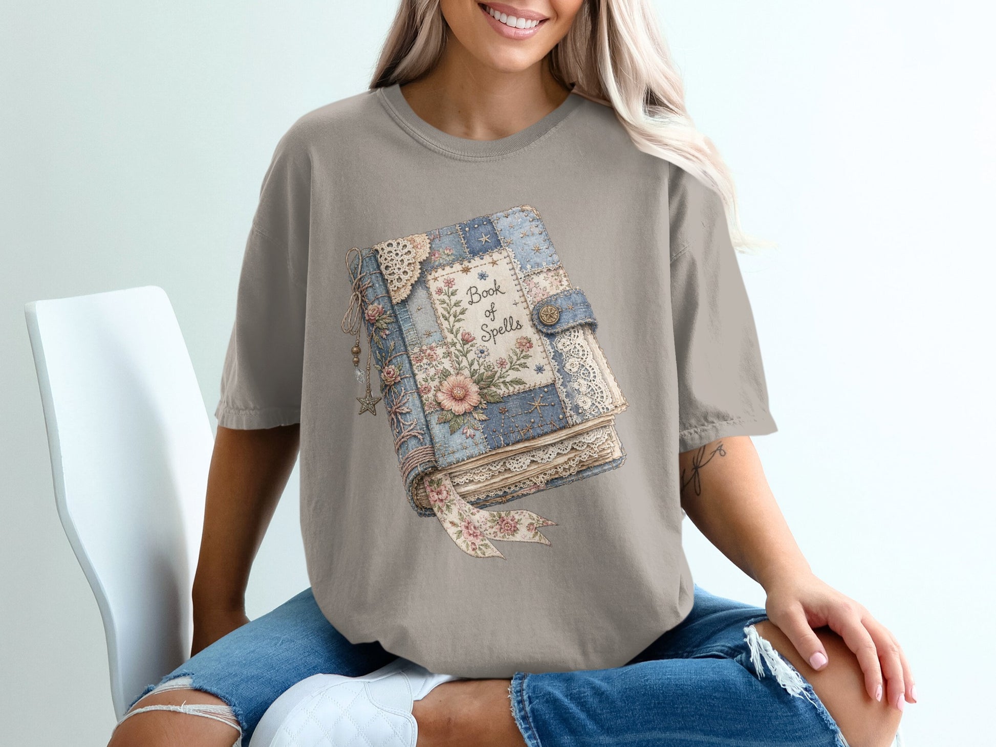 T-shirt with a "Book of Spells" graphic featuring a vintage floral book design.