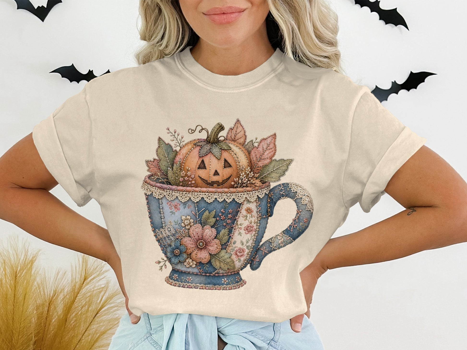 Jack-o'-lantern in teacup with floral and leaf accents.