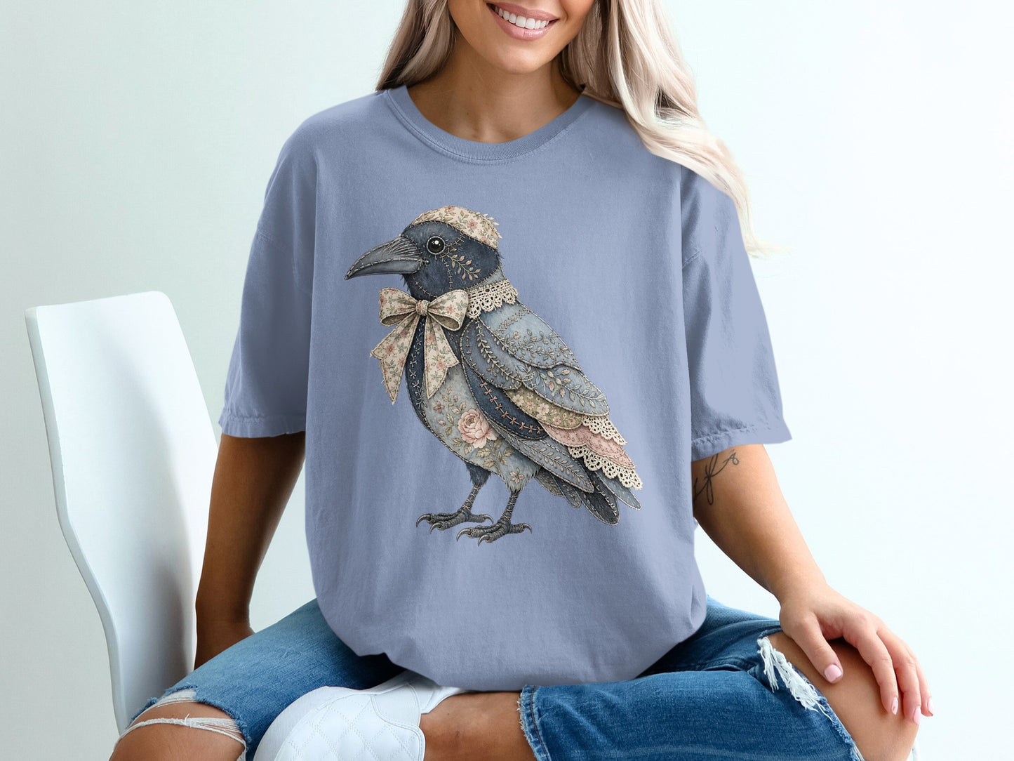 T-shirt with a collage-style crow wearing a floral bow and cap.