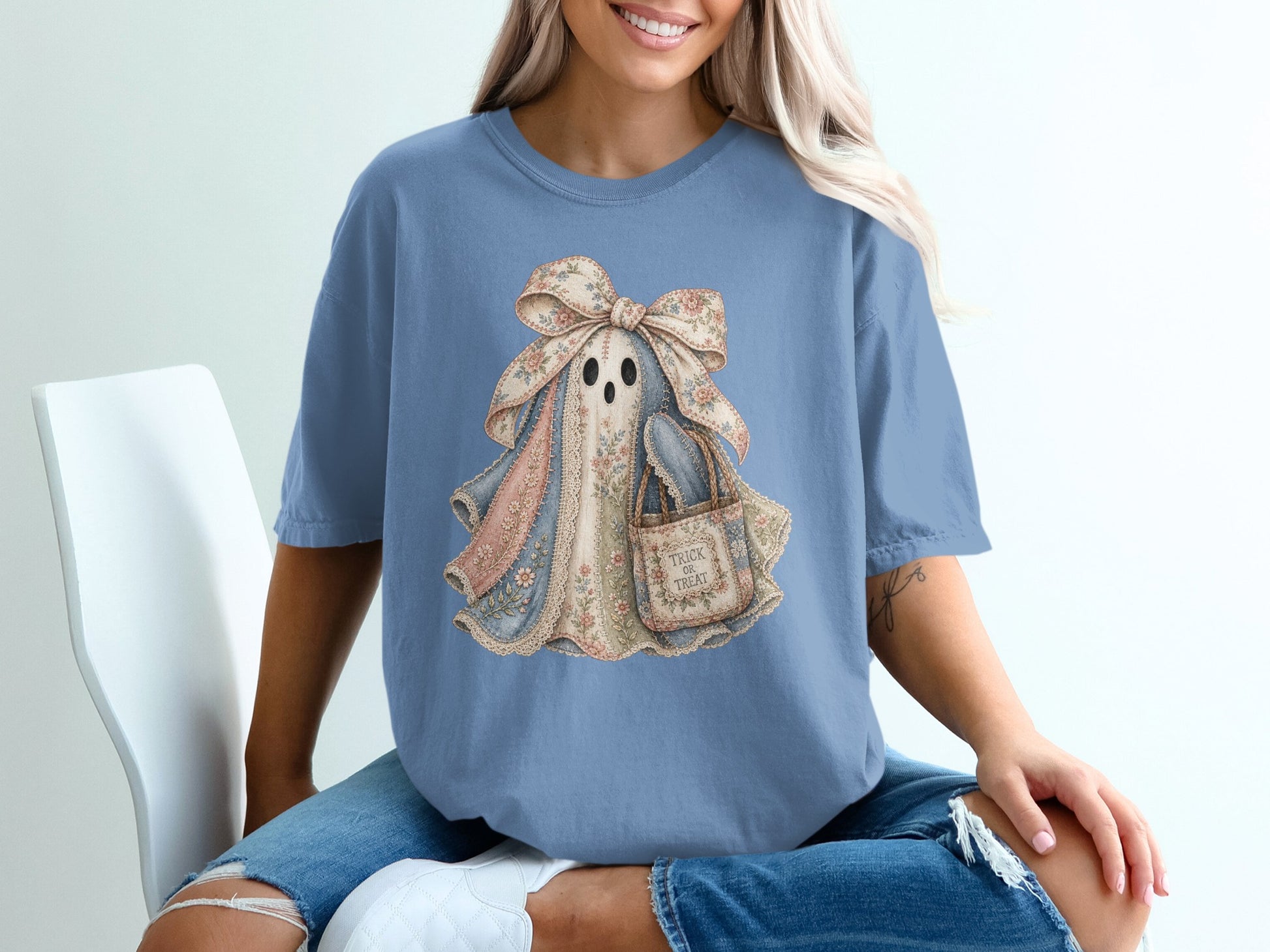 Fabric ghost with floral print bow and "Trick or Treat" bag on blue t-shirt.