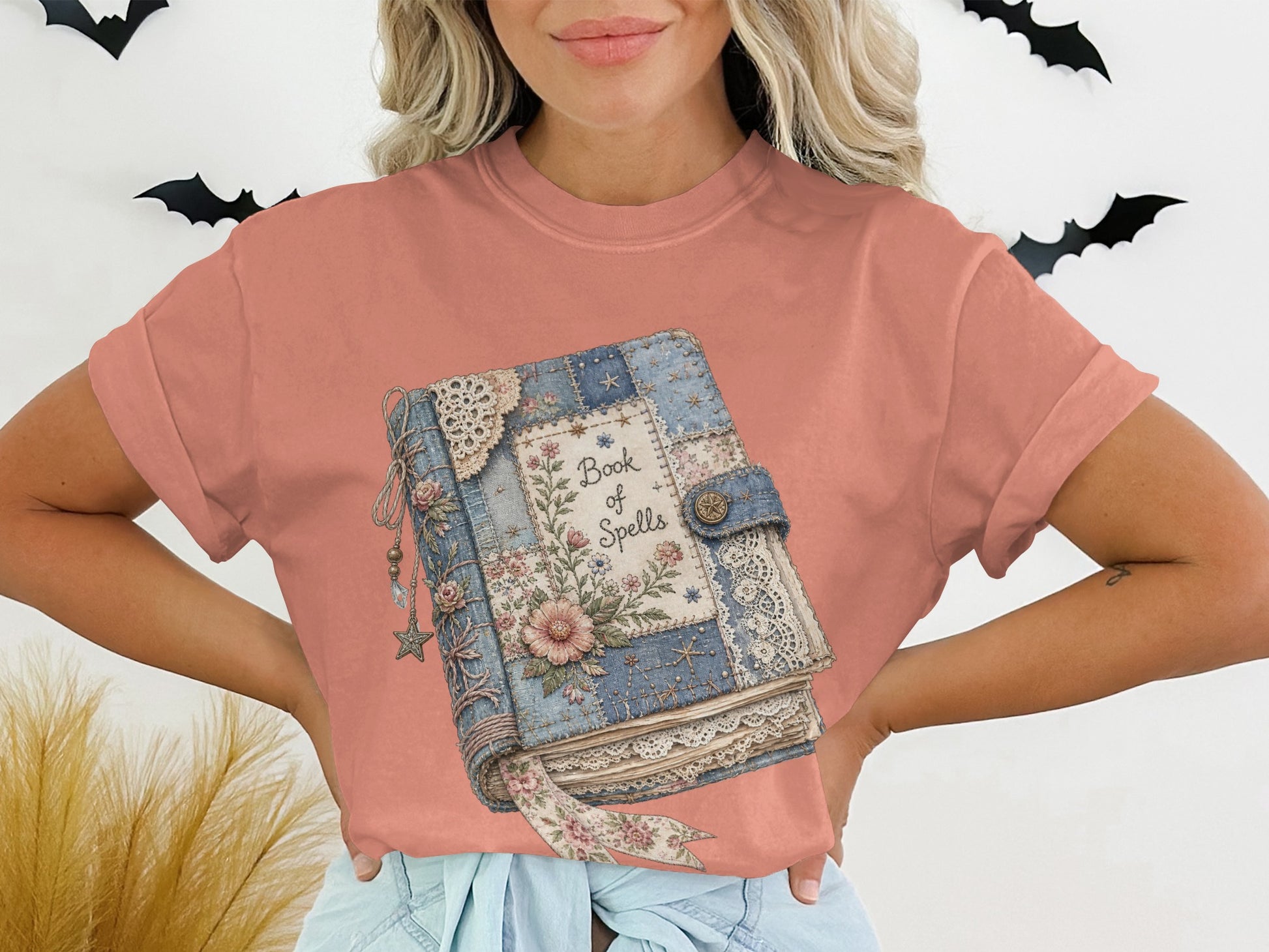 T-shirt graphic of a vintage-style book with "Book of Spells" text.