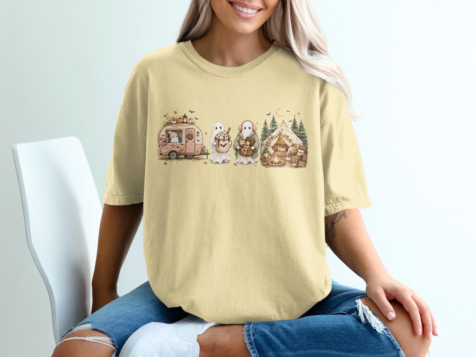 Yellow t-shirt with Halloween-themed graphic of ghosts, a camper, and a tent.