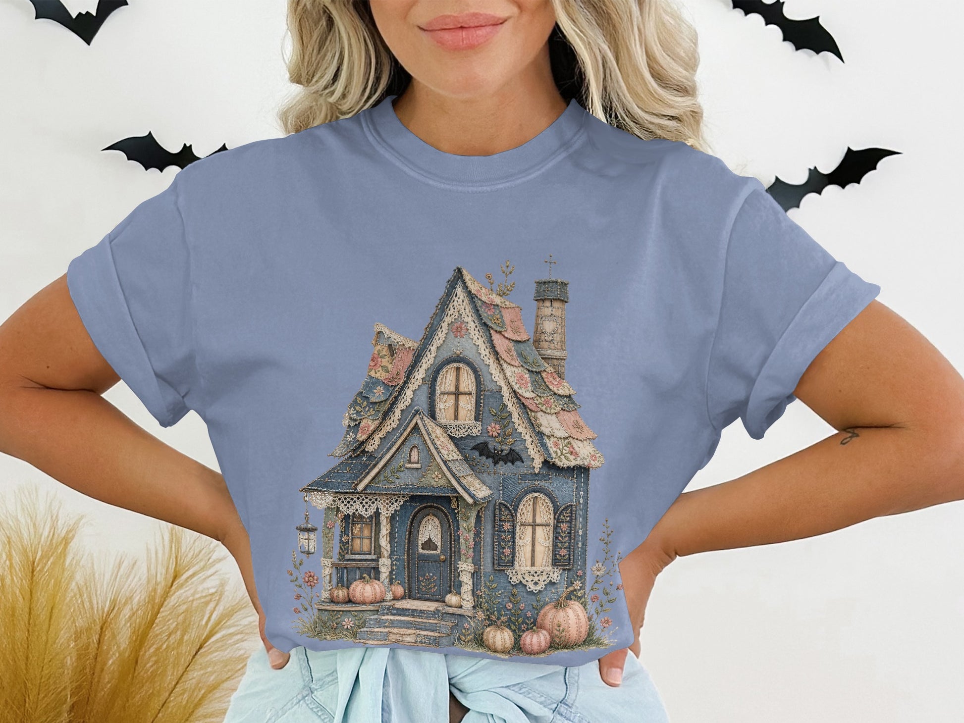 Blue t-shirt with a detailed illustration of a whimsical blue house with pumpkins.