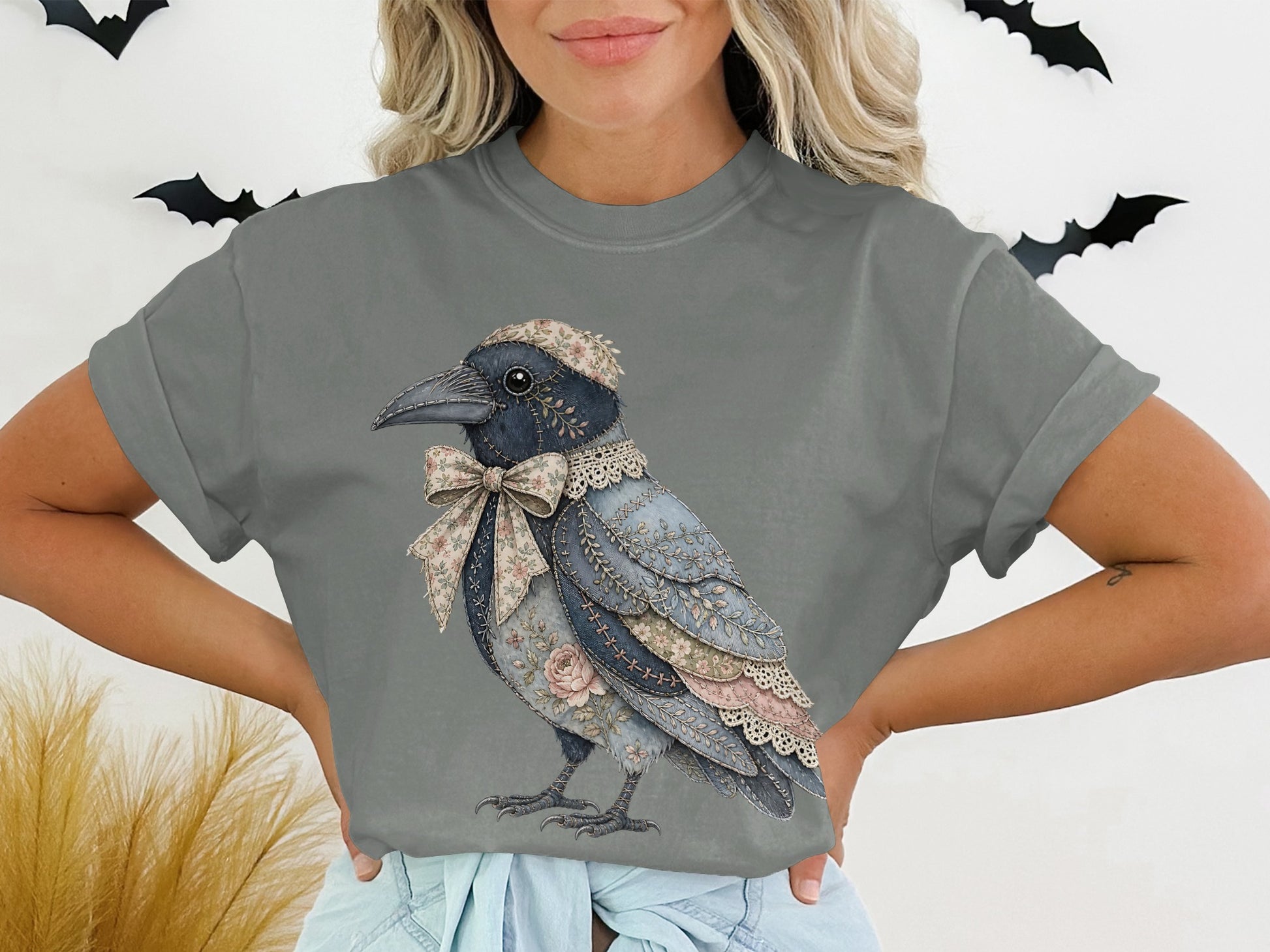 Gray t-shirt featuring a decorative crow with floral accents and bow.