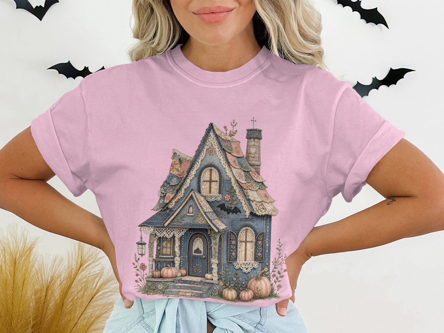 Pink crop top with a gothic cottage, pumpkins, and bats graphic.
