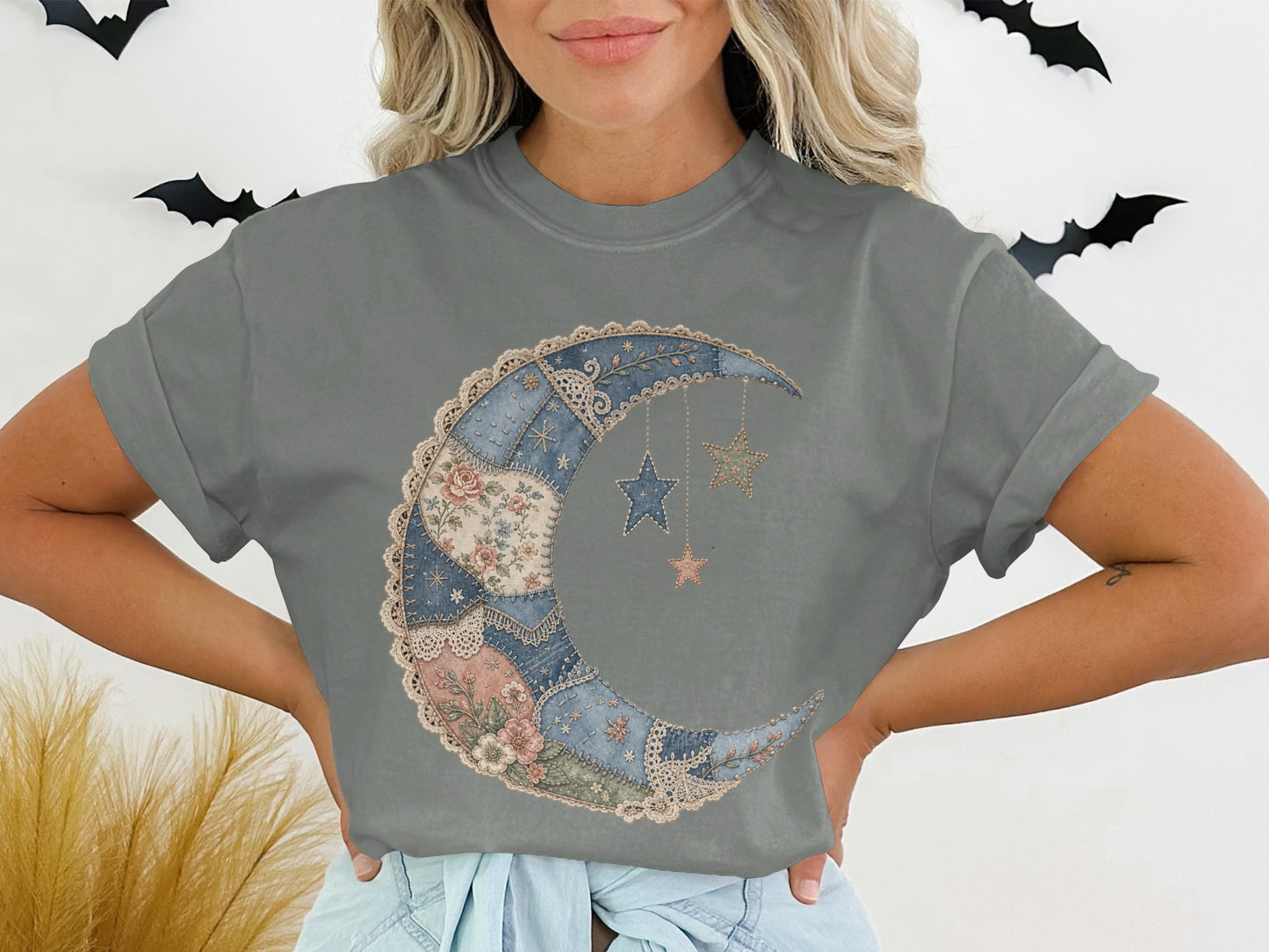 Gray t-shirt with a patchwork crescent moon and stars graphic.