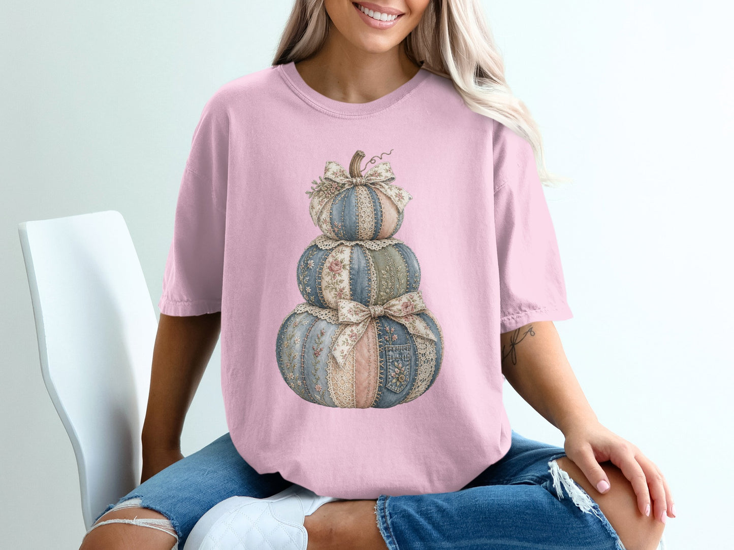 Pink t-shirt with stacked patchwork pumpkins and floral bows graphic.
