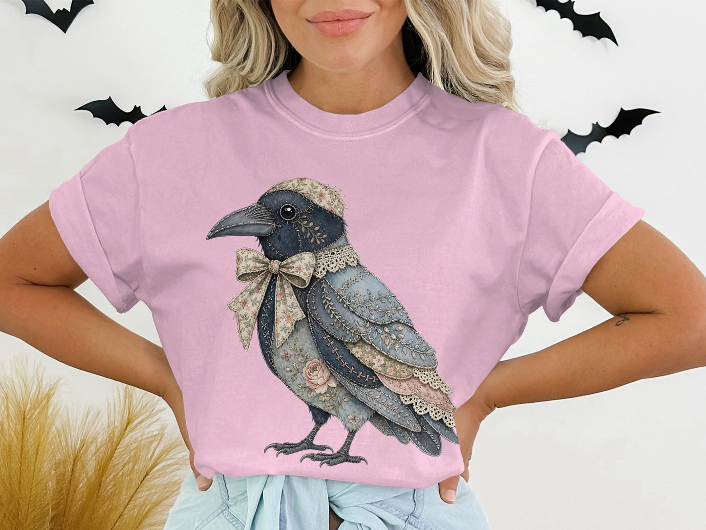 Pink t-shirt with a graphic of a crow wearing a floral hat and bow.