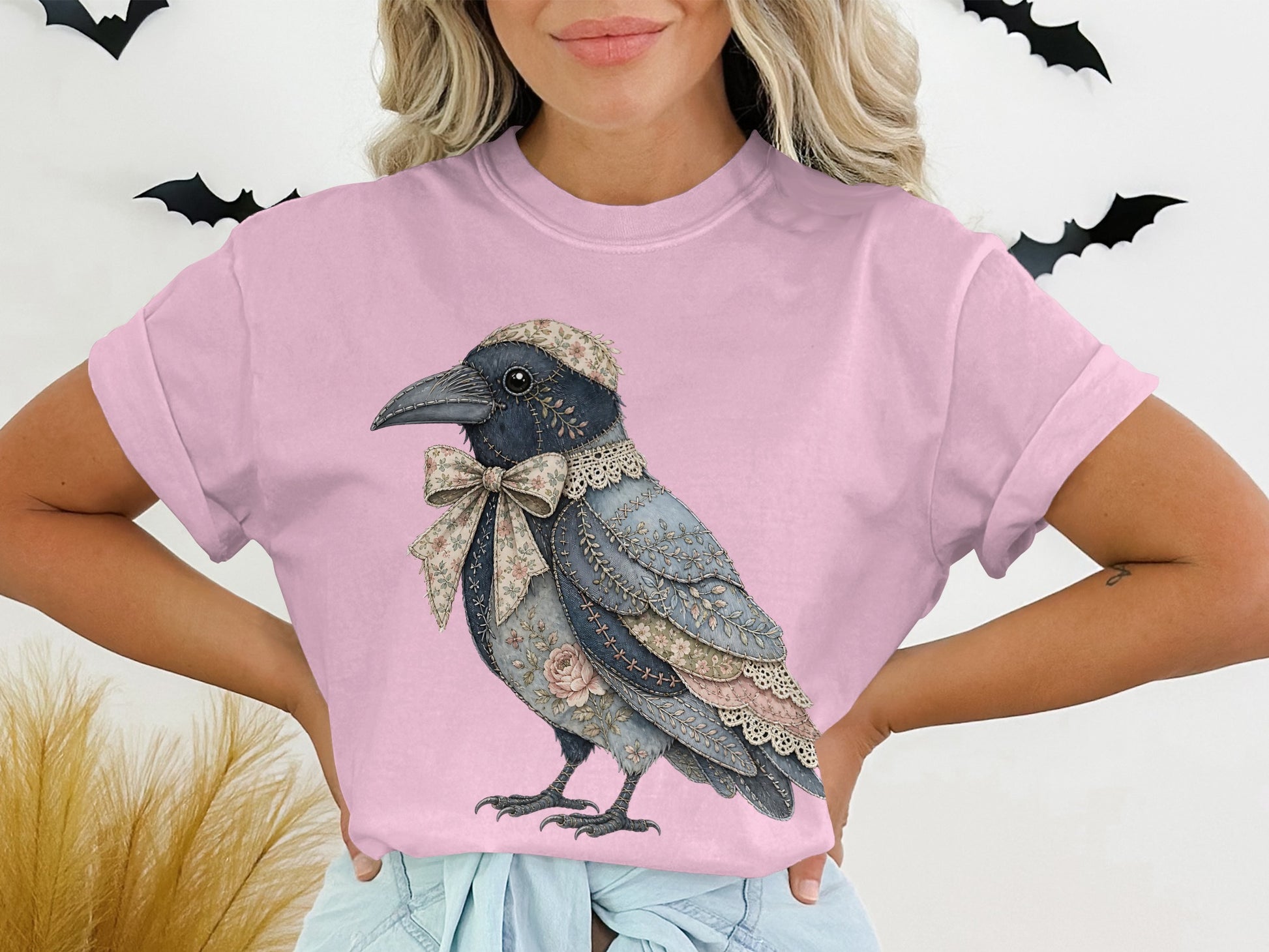 Pink t-shirt with a graphic of a crow wearing a floral hat and bow.