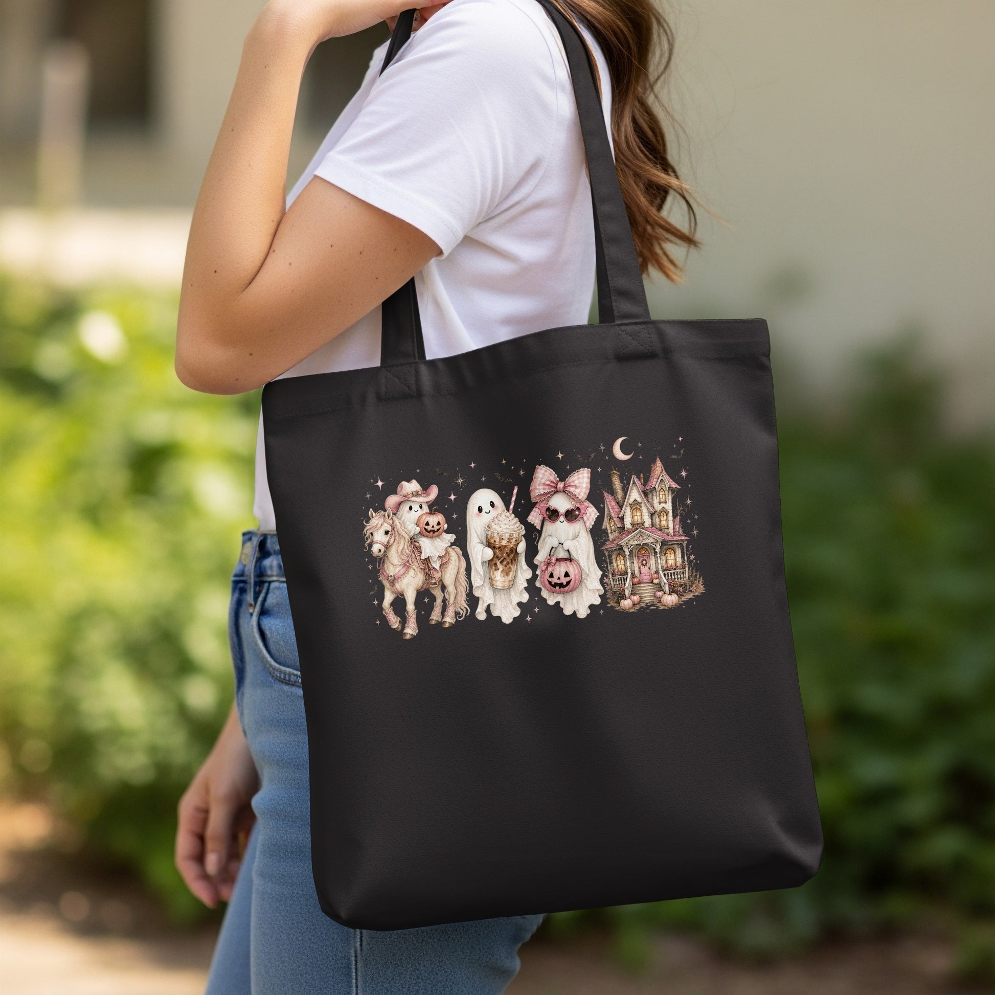 Black tote bag with Halloween ghosts, a horse, and a haunted house graphic.