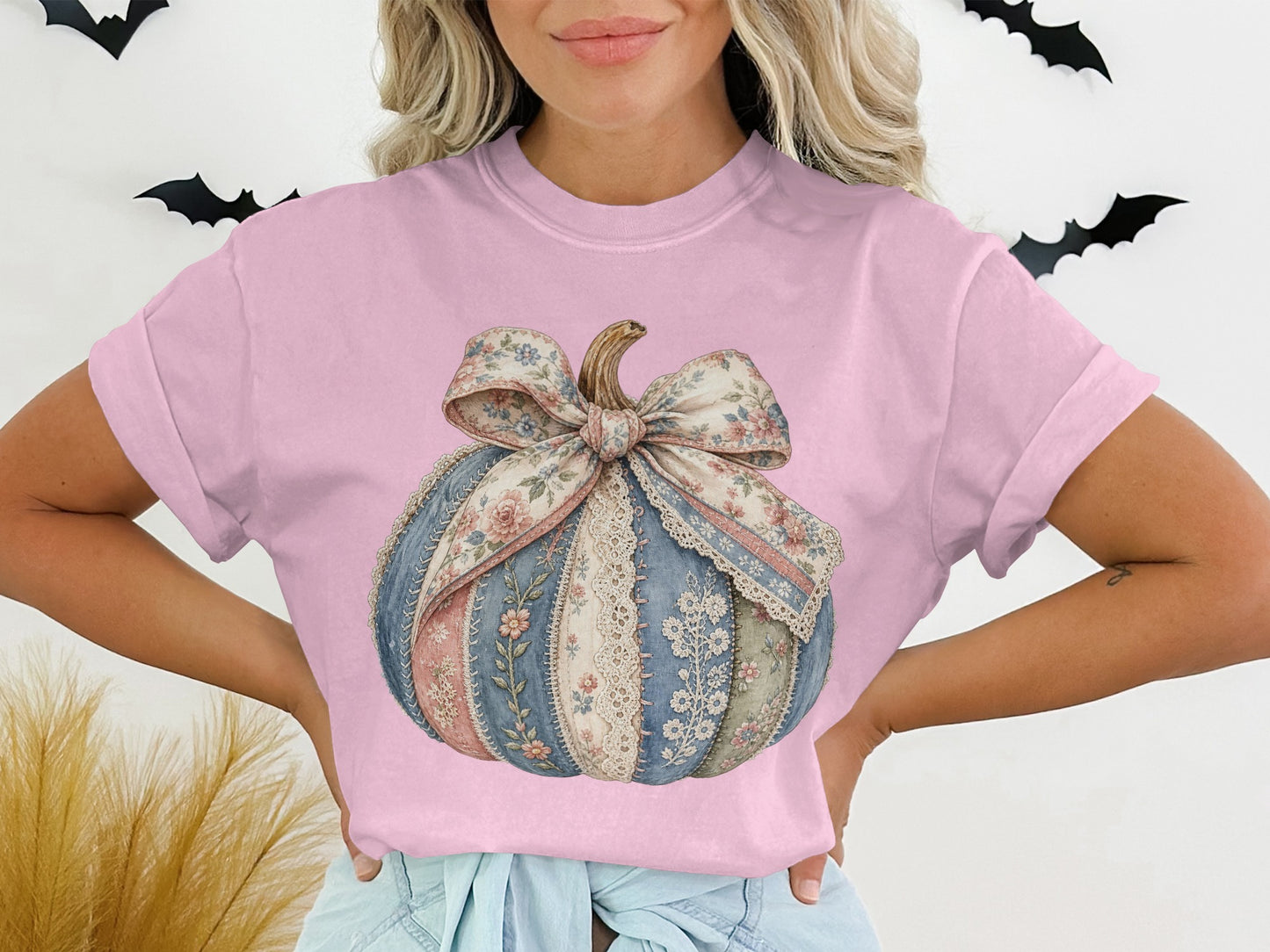 Pink t-shirt with a floral patchwork pumpkin graphic and a bow.