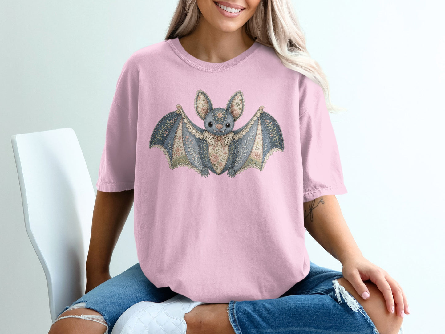 Pink t-shirt with a vintage floral bat graphic and lace trim.