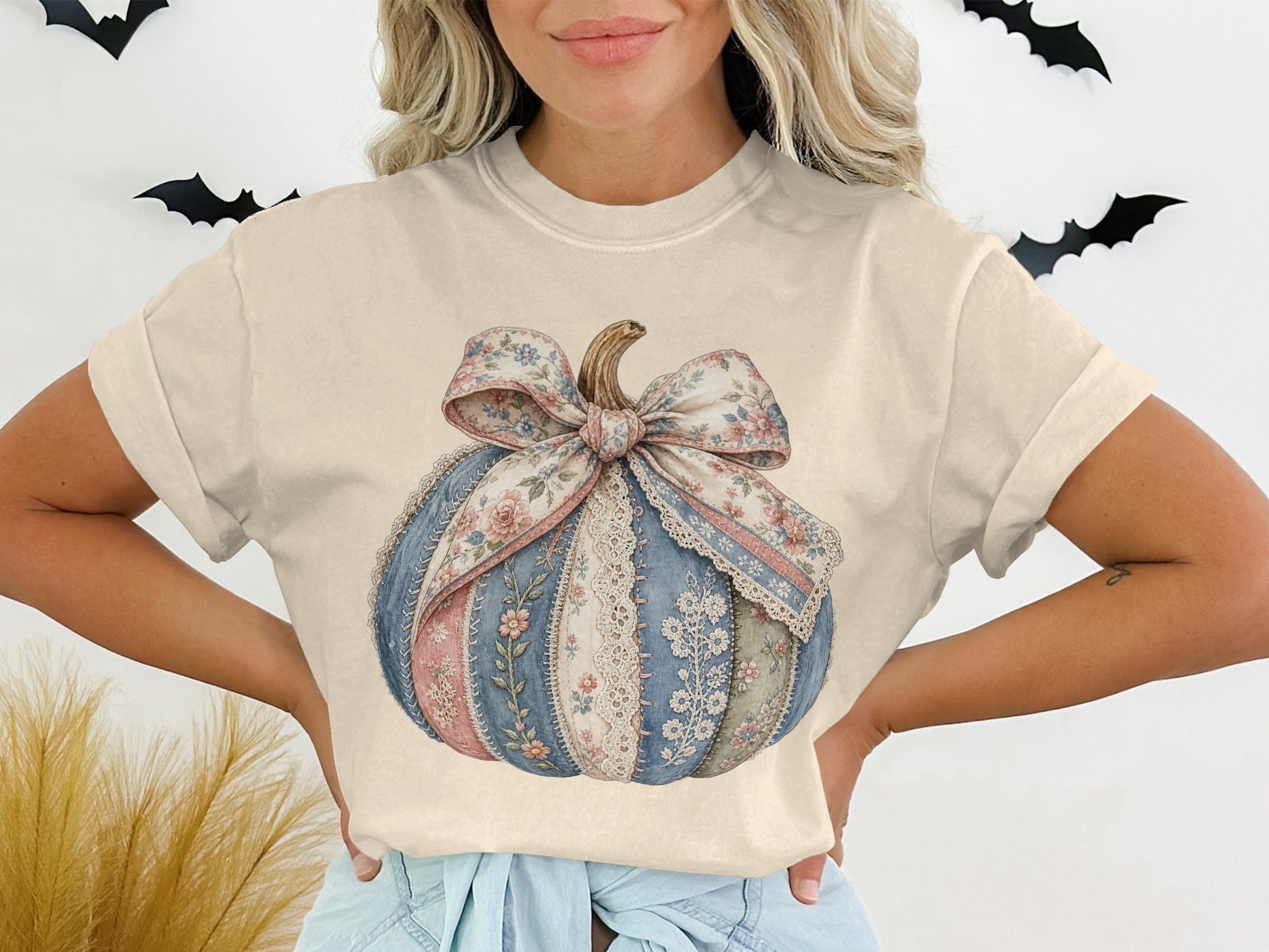 Cream t-shirt with a patchwork pumpkin graphic accented by a floral bow.