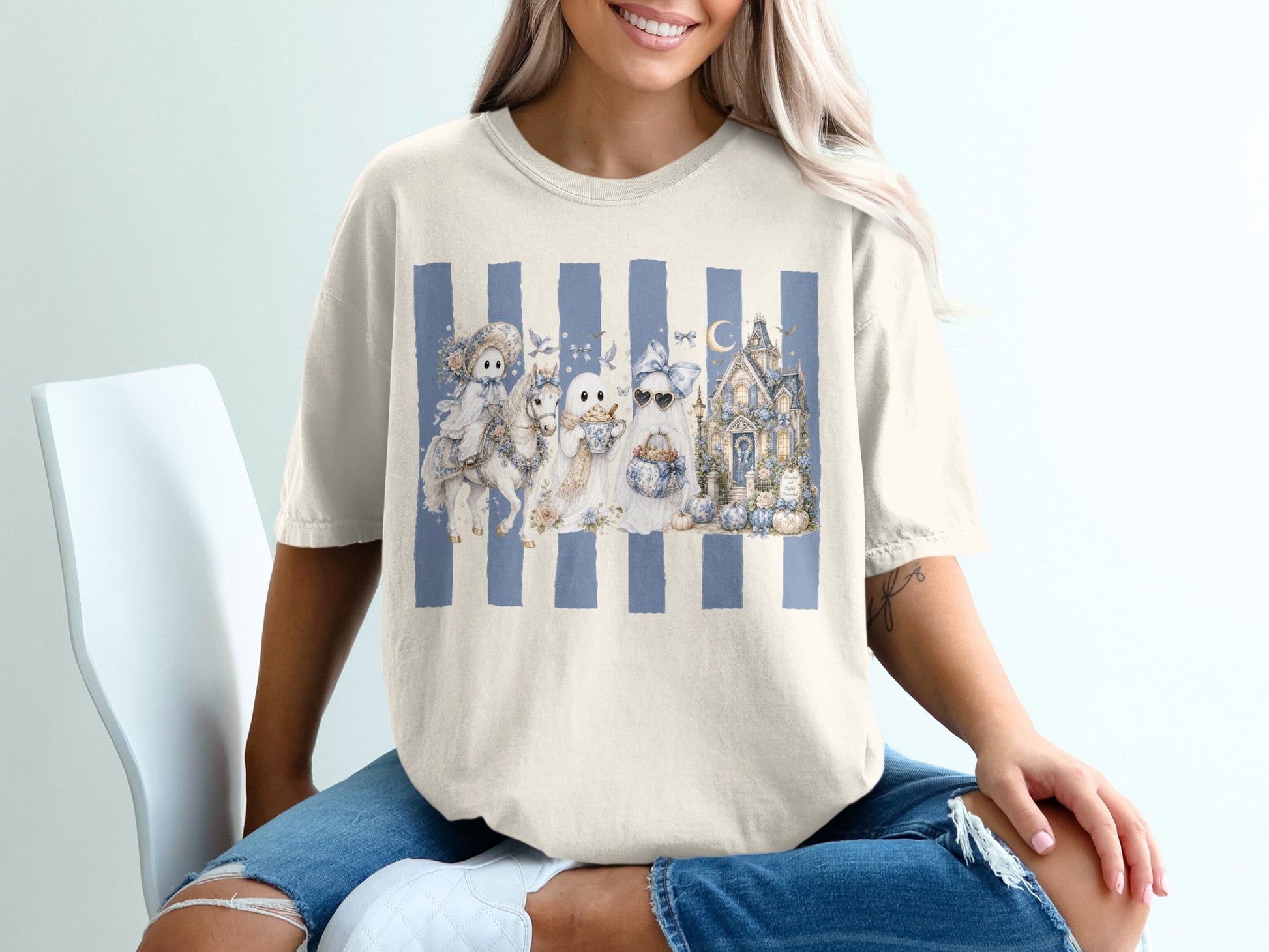 Ghosts and a haunted house design on a cream t-shirt with blue stripes.