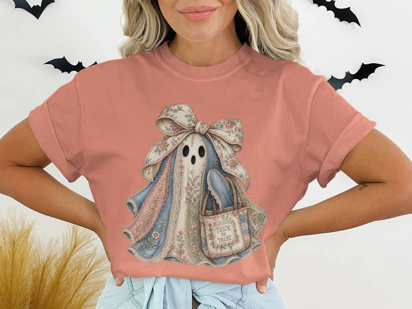 Coral t-shirt with a pastel patchwork ghost graphic holding a "Trick or Treat" bag.