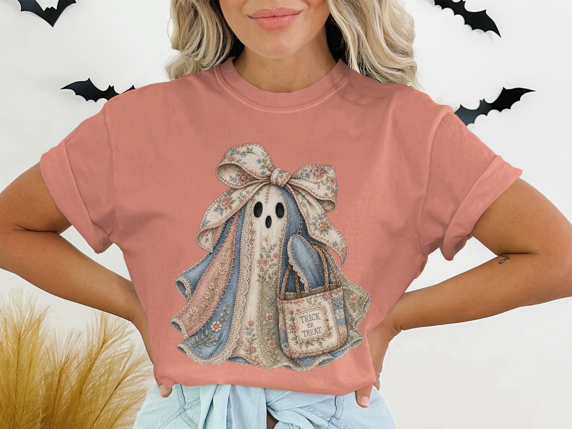Coral t-shirt with a pastel patchwork ghost graphic holding a "Trick or Treat" bag.