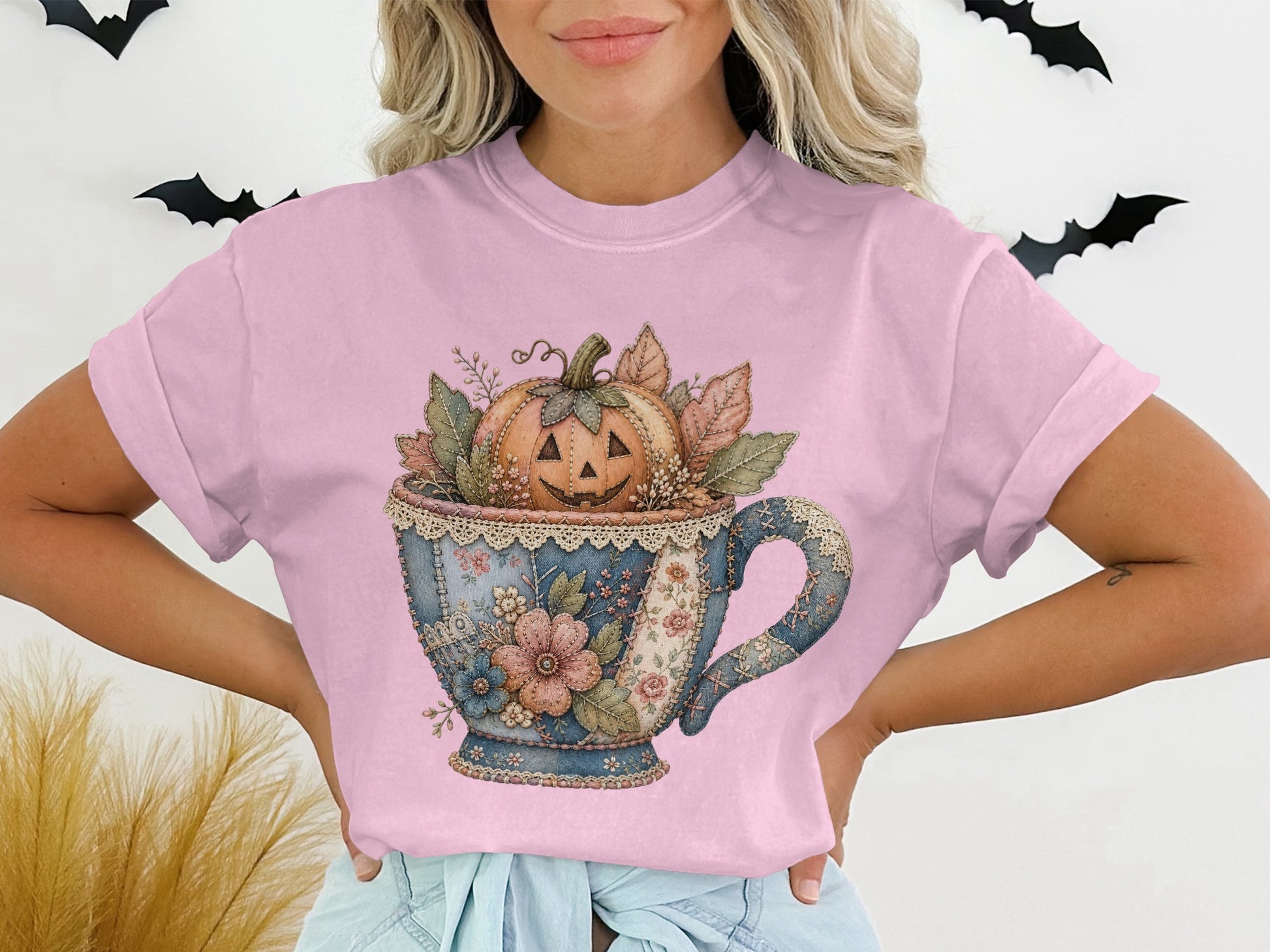Jack-o'-lantern in a patchwork teacup with floral and leaf accents.