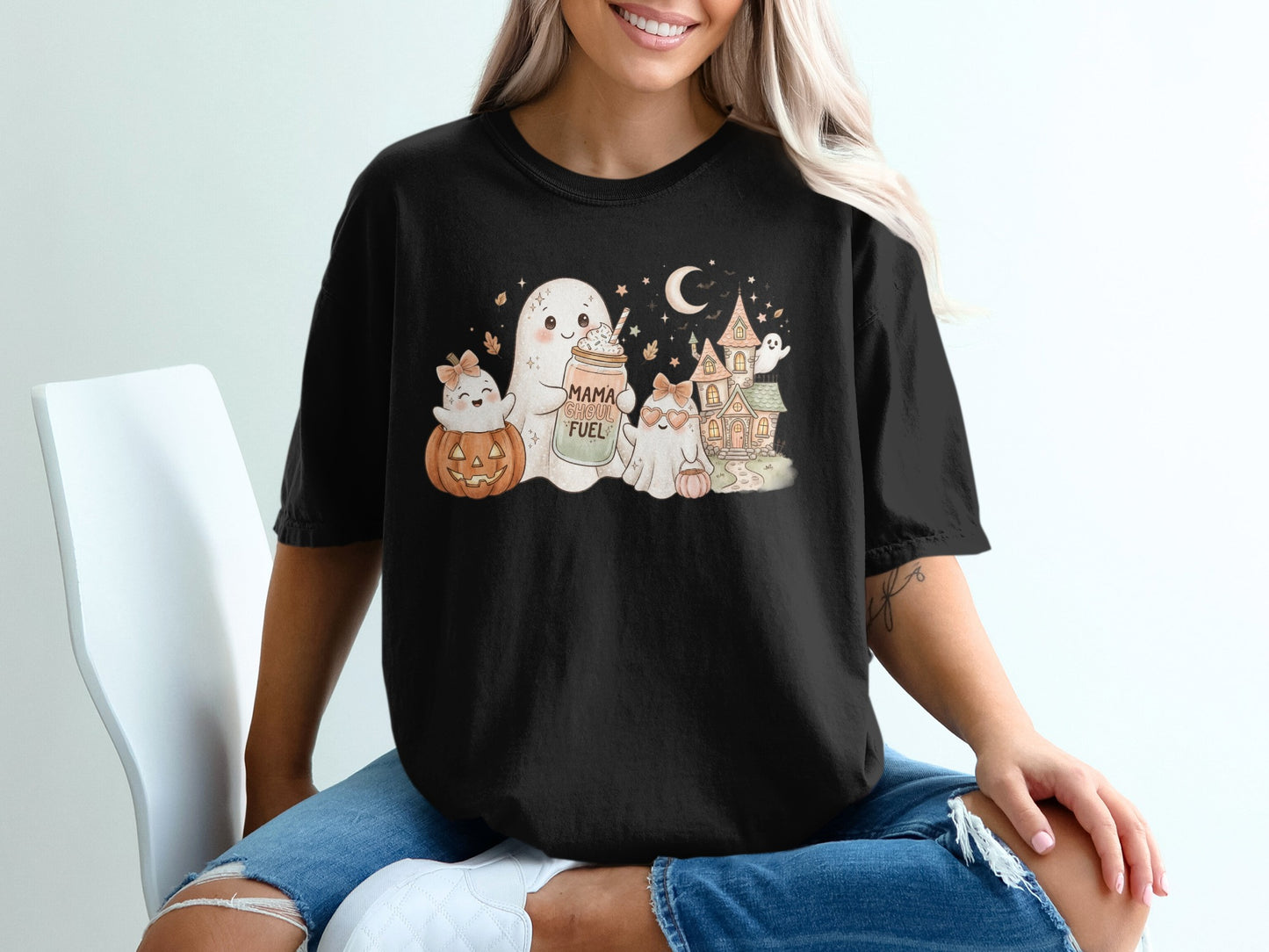 Halloween graphic tee with ghosts, pumpkin, haunted house, and "Mama Ghoul Fuel" text.